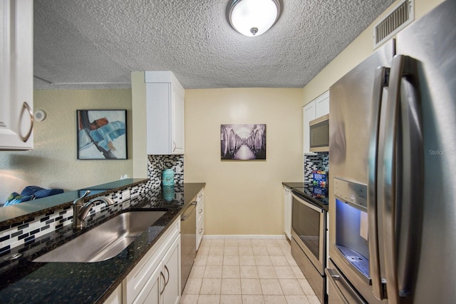 kitchen featuring stainless steel appliances, white cabinets, and backsplash