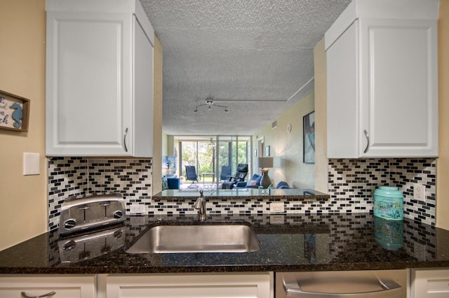 kitchen with white cabinetry, sink, and a textured ceiling