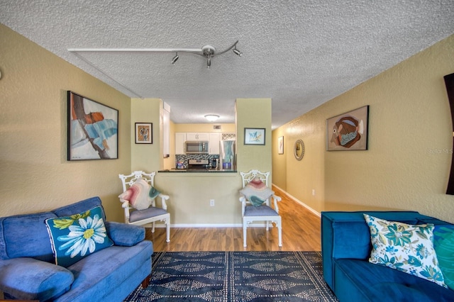 living room with a textured ceiling and hardwood / wood-style flooring