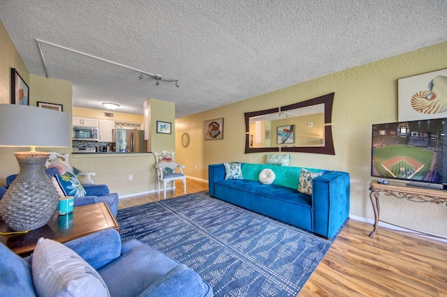 living room with track lighting, hardwood / wood-style floors, and a textured ceiling