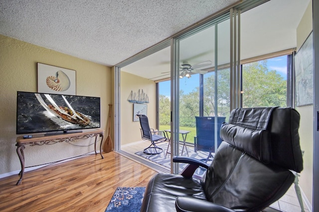 living room with a textured ceiling, ceiling fan, a wealth of natural light, and hardwood / wood-style floors