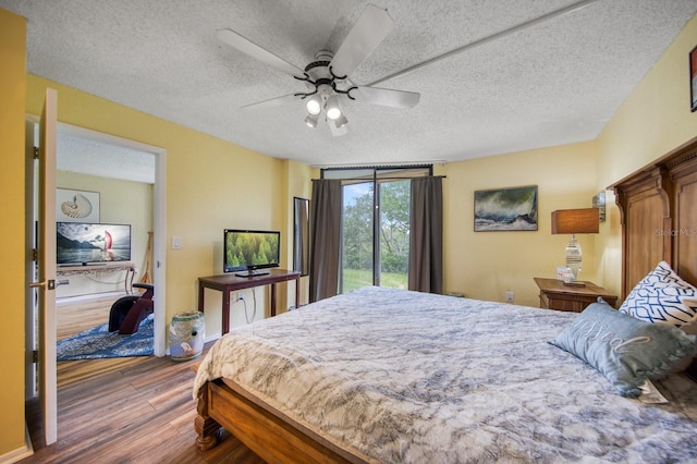 bedroom featuring access to exterior, ceiling fan, a textured ceiling, and dark hardwood / wood-style floors