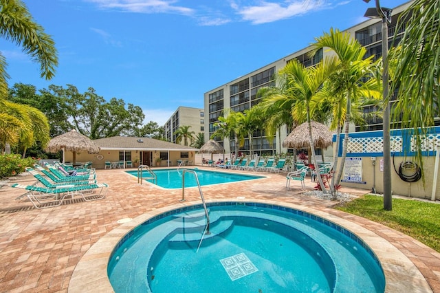 view of pool with a community hot tub and a patio