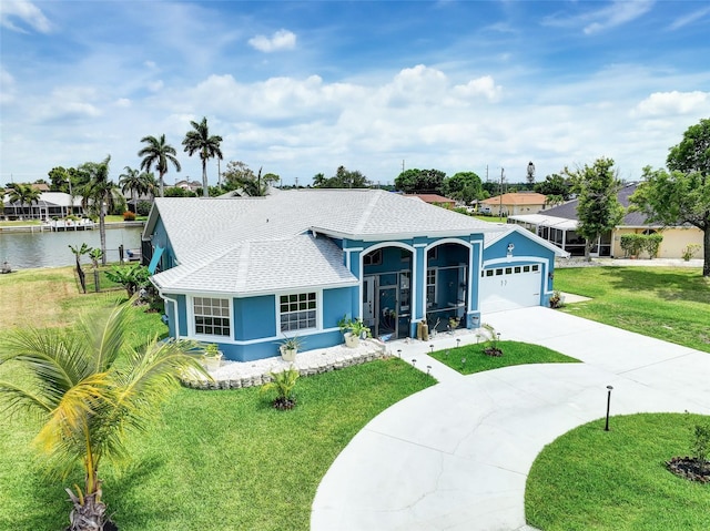 single story home with a front yard, a garage, and a water view