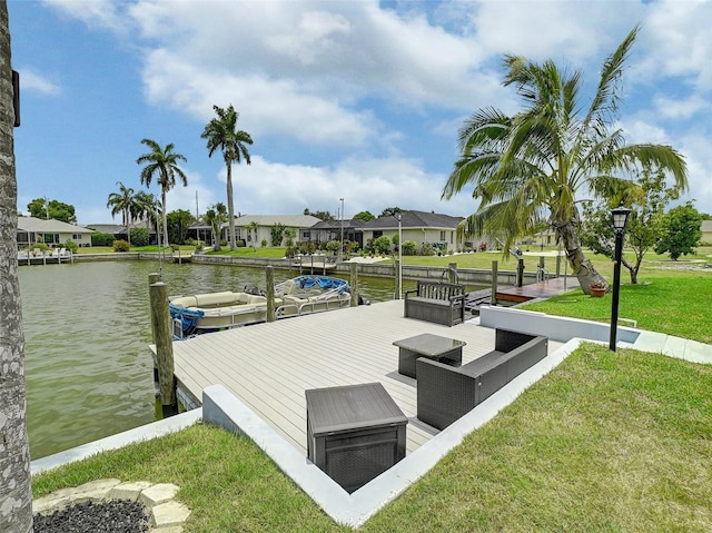 view of dock featuring outdoor lounge area, a water view, and a yard