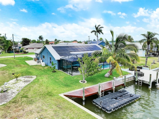 view of dock with a patio, a water view, and a yard