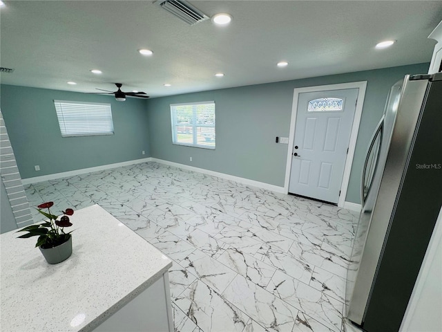 tiled entryway with ceiling fan