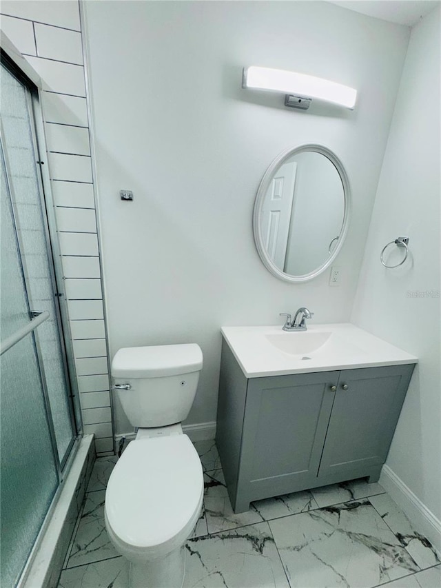 bathroom featuring tile floors, a shower with door, toilet, and vanity