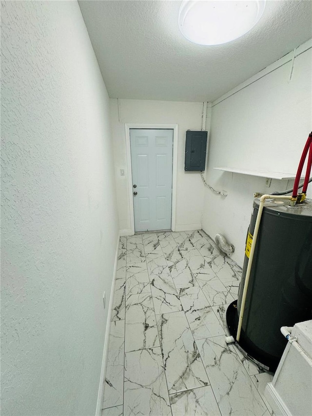 laundry area with a textured ceiling, gas water heater, and light tile floors