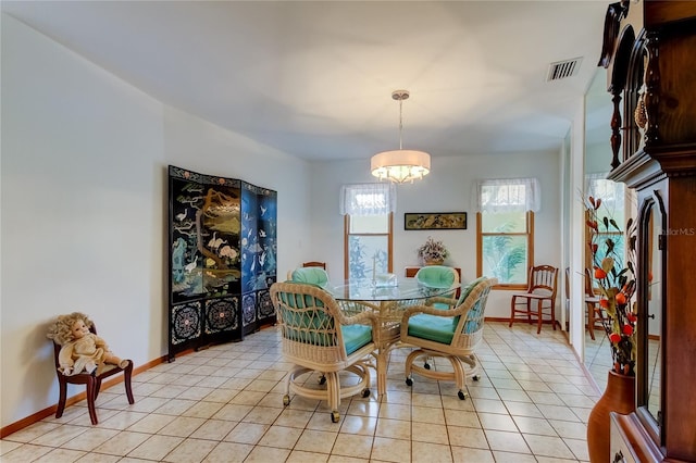 tiled dining room with an inviting chandelier