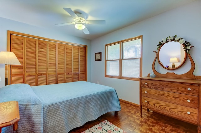 bedroom featuring parquet flooring, a closet, and ceiling fan