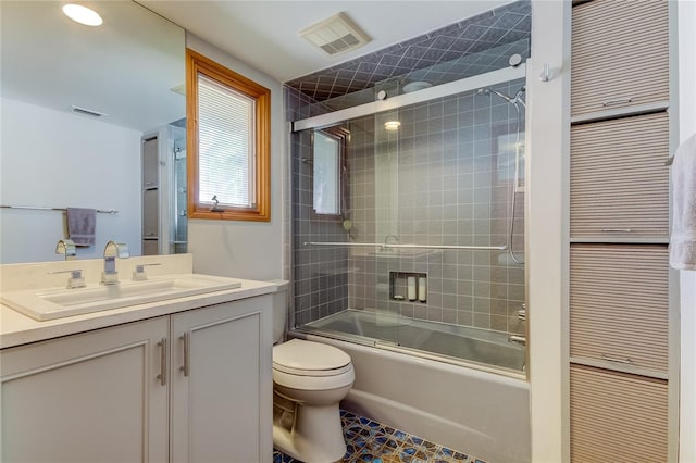 full bathroom with shower / bath combination with glass door, vanity, and toilet