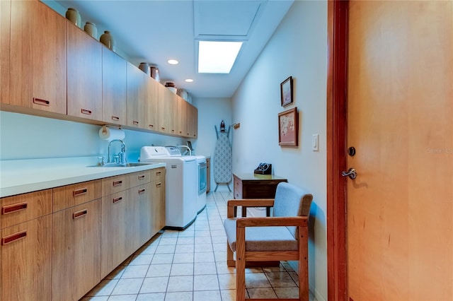 clothes washing area with washer and dryer, light tile patterned flooring, cabinets, and sink