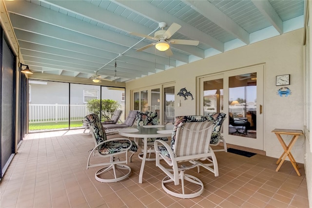 sunroom / solarium featuring ceiling fan and beam ceiling