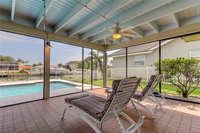 sunroom featuring beamed ceiling, plenty of natural light, and ceiling fan