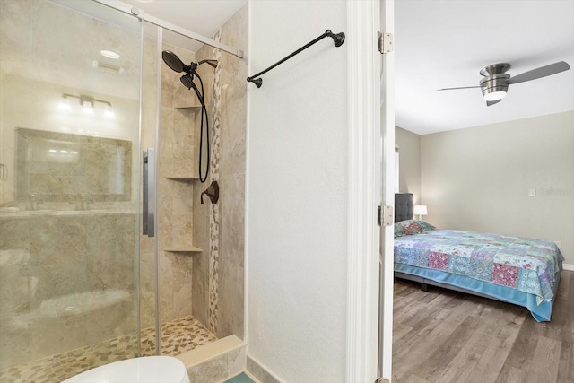 bathroom with ceiling fan, walk in shower, hardwood / wood-style floors, and toilet