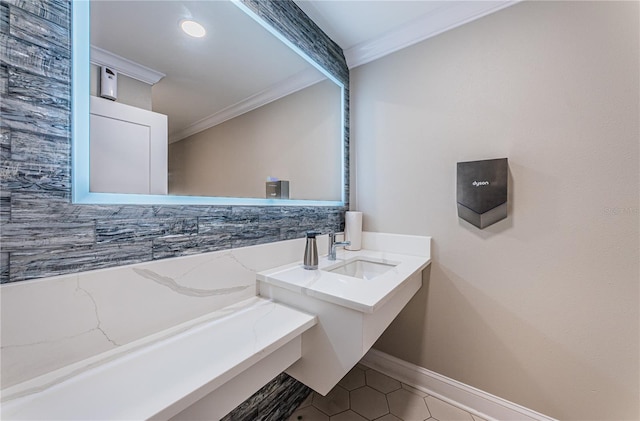 bathroom featuring tile patterned floors, crown molding, and sink