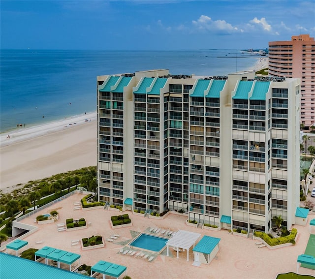 view of building exterior featuring a water view and a view of the beach