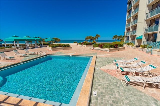 view of pool featuring a gazebo, a water view, and a patio