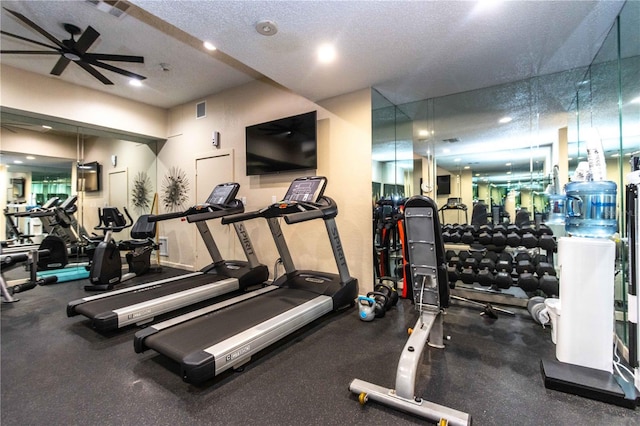 gym with ceiling fan and a textured ceiling