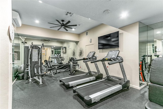 exercise room featuring a textured ceiling, ceiling fan, and a wall mounted air conditioner