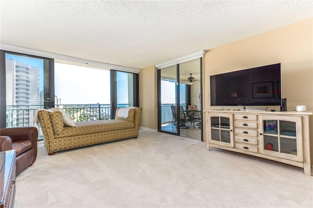 carpeted living room with floor to ceiling windows, a healthy amount of sunlight, and a textured ceiling