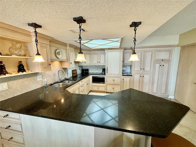 kitchen with sink, decorative backsplash, decorative light fixtures, a kitchen bar, and kitchen peninsula