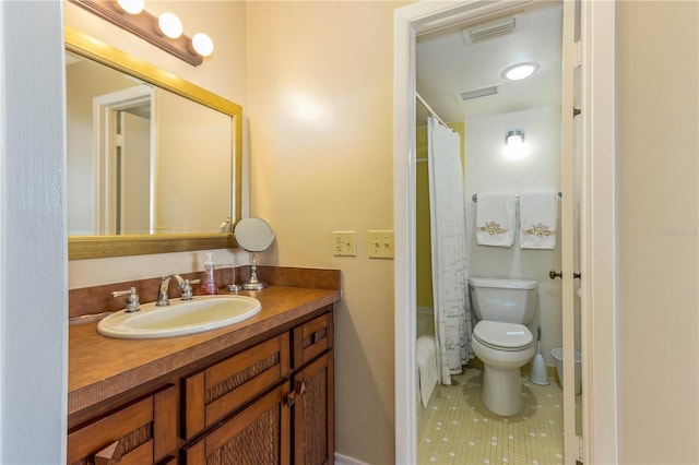 bathroom with tile patterned flooring, vanity, and toilet