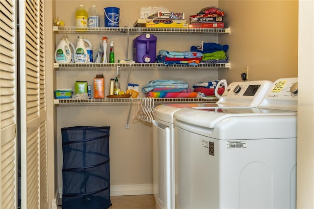 clothes washing area featuring tile patterned flooring and washing machine and clothes dryer