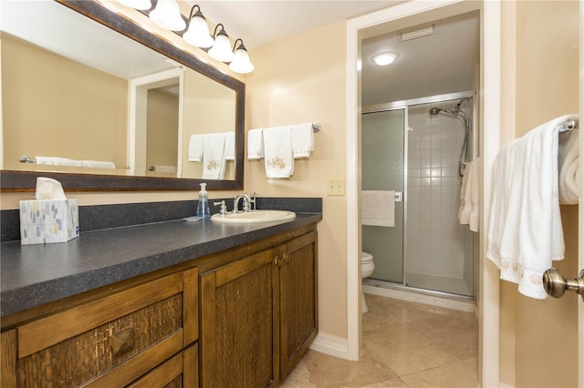 bathroom featuring tile patterned flooring, vanity, toilet, and walk in shower