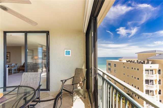 balcony with ceiling fan and a water view