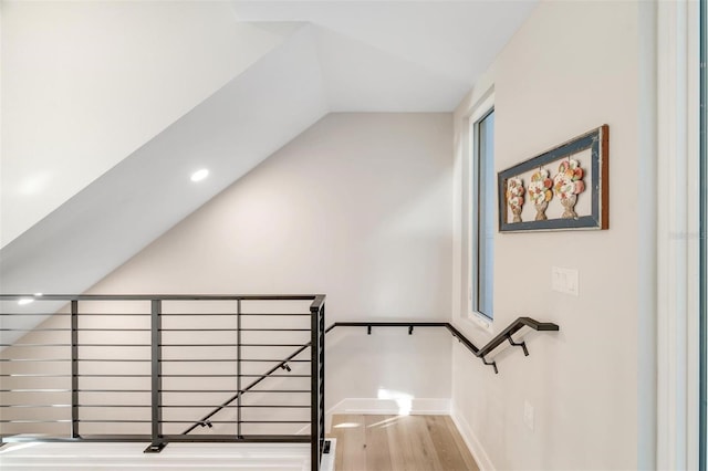 stairs featuring hardwood / wood-style floors and vaulted ceiling