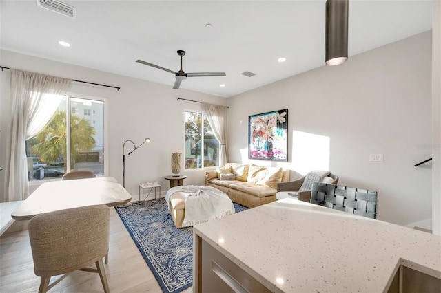 living room featuring light wood-type flooring and ceiling fan