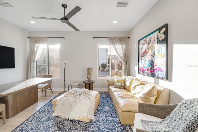 living room featuring ceiling fan and light hardwood / wood-style flooring