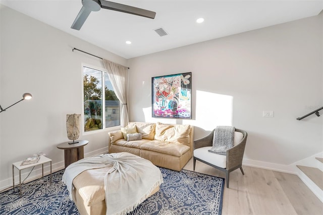 living room with light hardwood / wood-style flooring and ceiling fan