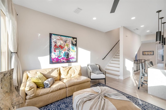 living room featuring light hardwood / wood-style flooring and ceiling fan