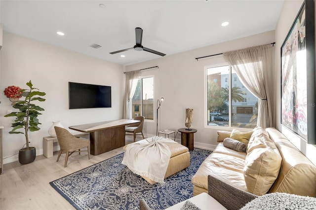 living room with ceiling fan, a healthy amount of sunlight, and light hardwood / wood-style flooring