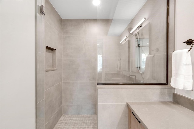 bathroom featuring vanity and tiled shower