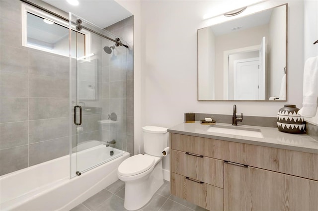 full bathroom with tile patterned floors, vanity, toilet, and shower / bath combination with glass door