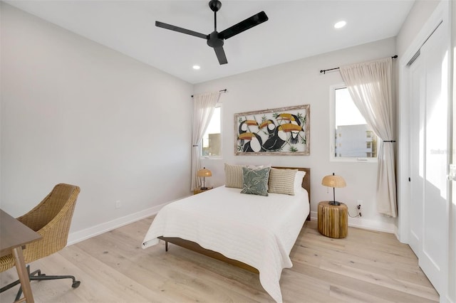 bedroom with light wood-type flooring, a closet, and ceiling fan