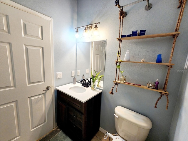 bathroom featuring tile patterned flooring, vanity, and toilet