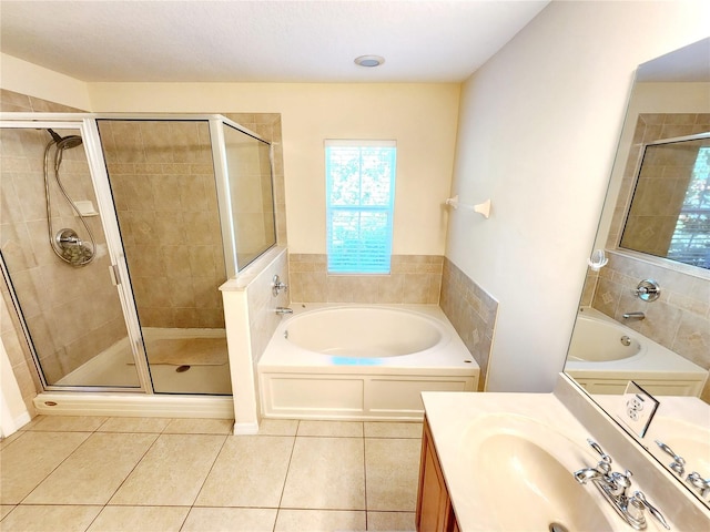 bathroom with tile patterned flooring, vanity, and shower with separate bathtub