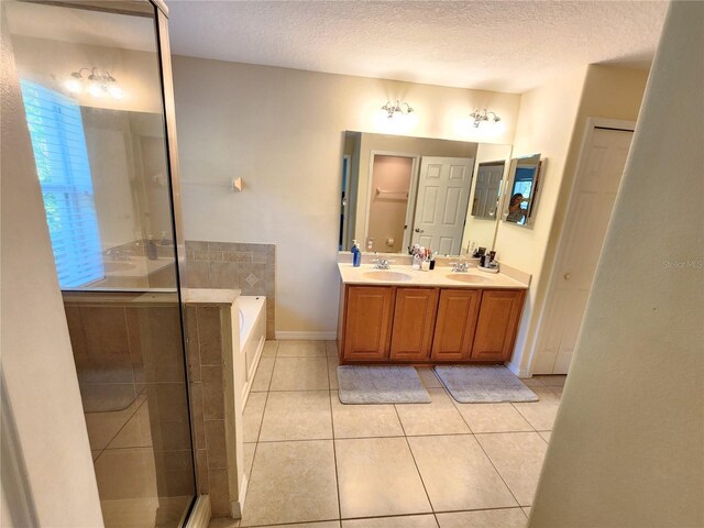 bathroom featuring tile patterned floors, vanity, shower with separate bathtub, and a textured ceiling