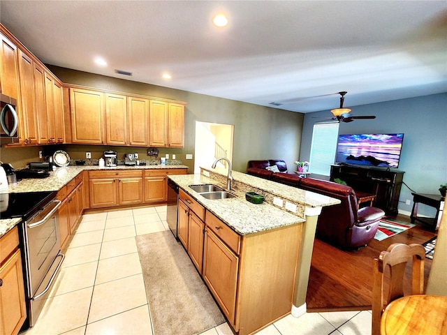 kitchen with light tile patterned floors, stainless steel appliances, ceiling fan, and sink