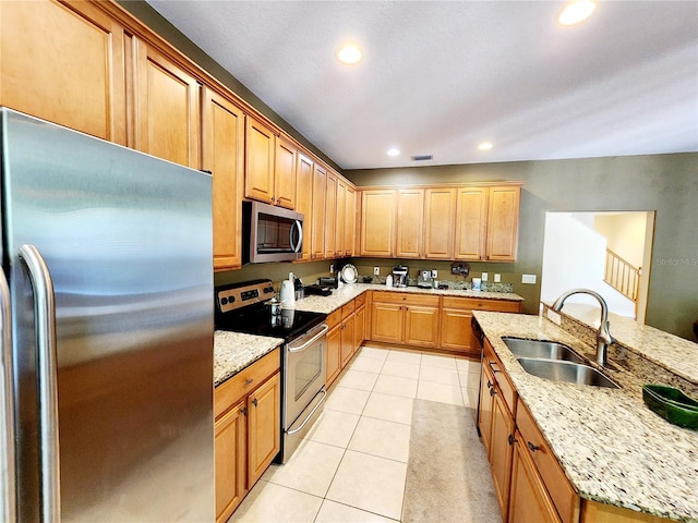 kitchen featuring stainless steel appliances, sink, light tile patterned floors, and light stone counters