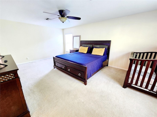 bedroom with ceiling fan and light carpet