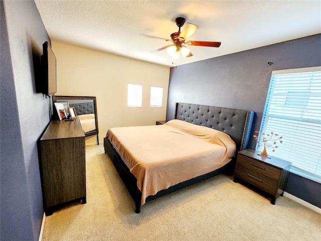 carpeted bedroom with ceiling fan and a textured ceiling