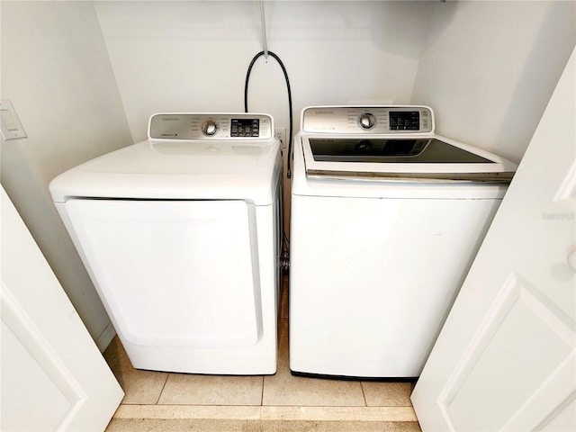 laundry room featuring light tile patterned flooring and washer and clothes dryer