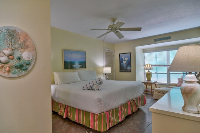 bedroom with dark tile patterned flooring and ceiling fan