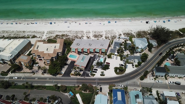 birds eye view of property with a water view and a beach view